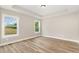 A light-filled bedroom offers abundant natural light from two windows and wood-look flooring at 7327 Shawan Rd, Wendell, NC 27591