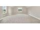 Spacious bedroom with neutral carpeting and natural light from two large windows at 7327 Shawan Rd, Wendell, NC 27591