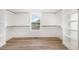 A walk-in closet is equipped with wood shelving and a large window with great natural light at 7327 Shawan Rd, Wendell, NC 27591