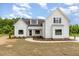 Stunning white farmhouse-style home with black accents, lush landscaping, and a beautiful curved walkway at 7327 Shawan Rd, Wendell, NC 27591