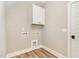 A convenient laundry room features a storage cabinet, connections for appliances, and durable wood-look flooring at 7327 Shawan Rd, Wendell, NC 27591