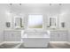 Luxurious bathroom featuring a freestanding tub, dual vanities, and modern lighting fixtures at 5305 Dixon Dr, Raleigh, NC 27609