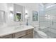 Bright bathroom featuring a shower with glass doors and a gray wood vanity at 5305 Dixon Dr, Raleigh, NC 27609