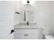 Bright bathroom featuring an arched mirror, sleek vanity with granite countertop, and modern fixtures at 5305 Dixon Dr, Raleigh, NC 27609