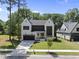 Stunning modern home showcasing black trim, a paved driveway, and lush green grass at 5305 Dixon Dr, Raleigh, NC 27609