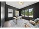Stylish home office with wainscoting, large windows, modern light fixture and gray patterned rug at 5305 Dixon Dr, Raleigh, NC 27609
