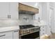 Close-up of the gourmet gas cooktop with pot filler and light tile backsplash at 5305 Dixon Dr, Raleigh, NC 27609