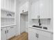 Laundry room with storage cabinets, shelves, and sink with modern faucet at 5305 Dixon Dr, Raleigh, NC 27609