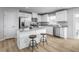 Bright kitchen with white cabinets, stainless steel appliances, and a granite island with seating at 356 N Coral Bells Way Way, Four Oaks, NC 27524