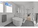 Bright bathroom featuring freestanding tub, glass shower, and gray tile flooring at 100 Farris Ct, Raleigh, NC 27610