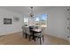 Bright dining room featuring a modern chandelier, a dark wood table and scenic backyard views through large windows at 100 Farris Ct, Raleigh, NC 27610