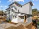 New construction showing the side and front of the house, with a covered porch and an orange door at 100 Farris Ct, Raleigh, NC 27610