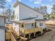 A modern two-story home showcasing a light gray exterior and a spacious wooden deck at 100 Farris Ct, Raleigh, NC 27610