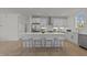 Spacious kitchen with white cabinets, stainless steel appliances, an island, and bar stool seating at 100 Farris Ct, Raleigh, NC 27610