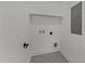 Utility room with gray tile flooring and convenient washer and dryer hookups and wall storage at 100 Farris Ct, Raleigh, NC 27610