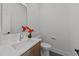 Stylish powder room featuring a modern vanity, mosaic tile floor, and decorative floral arrangement at 100 Farris Ct, Raleigh, NC 27610