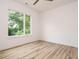 Bright bedroom with light wood floors, a large window, and neutral wall colors at 1521 Havenmont Ct, Raleigh, NC 27608
