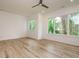 Bright bedroom features large windows providing scenic views of lush greenery and a ceiling fan at 1521 Havenmont Ct, Raleigh, NC 27608