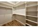 Well-organized walk-in closet featuring ample shelving and wooden floors at 1521 Havenmont Ct, Raleigh, NC 27608