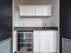 Convenient kitchenette featuring white cabinets, a stainless steel wine cooler, and a gray countertop at 1521 Havenmont Ct, Raleigh, NC 27608
