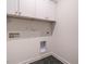 Functional laundry area featuring modern white cabinets and sleek hexagon tile flooring at 1521 Havenmont Ct, Raleigh, NC 27608