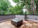 Modern rooftop deck with a contemporary fire pit, wood tile flooring, and lush surrounding greenery at 1521 Havenmont Ct, Raleigh, NC 27608
