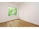 Bright bedroom with hardwood floors and a window view to the lush green outside at 1523 Havenmont Ct, Raleigh, NC 27608