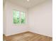 Bright bedroom with hardwood floors and a window view to the outside nature at 1523 Havenmont Ct, Raleigh, NC 27608