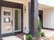Inviting entrance with a stylish door, brick pillar, and manicured landscaping for a welcoming appeal at 1523 Havenmont Ct, Raleigh, NC 27608