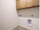 Laundry room with gray tile floor, overhead cabinets, and utility connections at 1523 Havenmont Ct, Raleigh, NC 27608