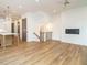 Open-concept living area with wood flooring, staircase, fireplace, and view into the kitchen at 1523 Havenmont Ct, Raleigh, NC 27608