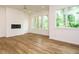 Bright living room with wood flooring, modern fireplace, and large windows offering plenty of natural light at 1523 Havenmont Ct, Raleigh, NC 27608