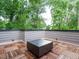 Relaxing rooftop deck with stylish wood flooring and a sleek fire pit, creating a cozy outdoor living space at 1523 Havenmont Ct, Raleigh, NC 27608