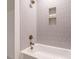 Bathroom shower with stylish gold fixtures, built-in niche, and a handheld shower head at 1523 Havenmont Ct, Raleigh, NC 27608