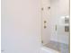 Bright shower featuring white tile and a glass door with gold fixtures at 1523 Havenmont Ct, Raleigh, NC 27608