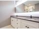 Modern bathroom featuring a double vanity with white cabinets and a large, illuminated mirror at 1525 Havenmont Ct, Raleigh, NC 27608