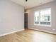 Bedroom featuring wood-look flooring, a window, neutral paint, and an interior door at 1525 Havenmont Ct, Raleigh, NC 27608
