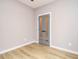 Neutral bedroom featuring modern wood-look floors and sleek glass-paneled doors at 1525 Havenmont Ct, Raleigh, NC 27608