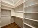 Spacious walk-in closet with custom shelving and wood rods for ample storage at 1525 Havenmont Ct, Raleigh, NC 27608