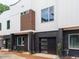 Modern townhouse featuring a brick facade, multi-paneled garage door, and contemporary architectural design at 1525 Havenmont Ct, Raleigh, NC 27608