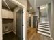 Hallway featuring laundry access and wooden stairs with iron rails, leading to a second floor at 1525 Havenmont Ct, Raleigh, NC 27608