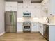 Bright kitchen featuring white cabinets, stainless steel appliances, marble backsplash and wood flooring at 1525 Havenmont Ct, Raleigh, NC 27608
