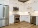 Bright kitchen with white cabinets, stainless steel appliances, and wood flooring at 1525 Havenmont Ct, Raleigh, NC 27608