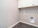 This laundry room features white cabinets above a black-tile floor and utility hookups for laundry machines at 1525 Havenmont Ct, Raleigh, NC 27608