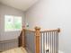 Staircase with wooden rails and iron balusters, leading up to a window and neutral wall paint at 1525 Havenmont Ct, Raleigh, NC 27608