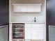 Convenient wet bar area with a marble countertop, white cabinets, and a wine fridge at 1525 Havenmont Ct, Raleigh, NC 27608