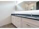 Modern bathroom featuring double vanity with white cabinets and gray counters at 1527 Havenmont Ct, Raleigh, NC 27608