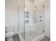 Gorgeous walk-in shower with glass surround and geometric floor tile at 1527 Havenmont Ct, Raleigh, NC 27608