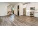 Open floor plan reveals kitchen with stainless steel appliances, white cabinets, and sleek flooring at 1527 Havenmont Ct, Raleigh, NC 27608