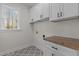 Laundry room with white cabinets, wood countertop and geometric tile floor at 143 Hook Dr # 23, Fuquay Varina, NC 27526